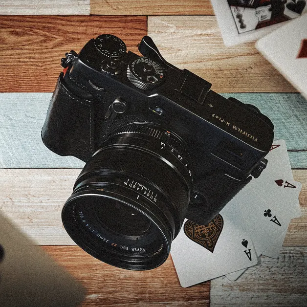 Fujifilm X-Pro3 on a painted wooden table with playing cards