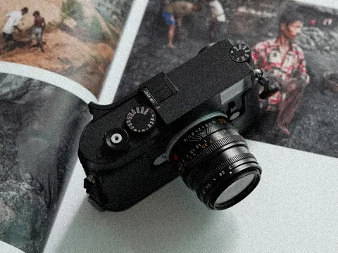 Leica rangefinder resting on an open photo book
